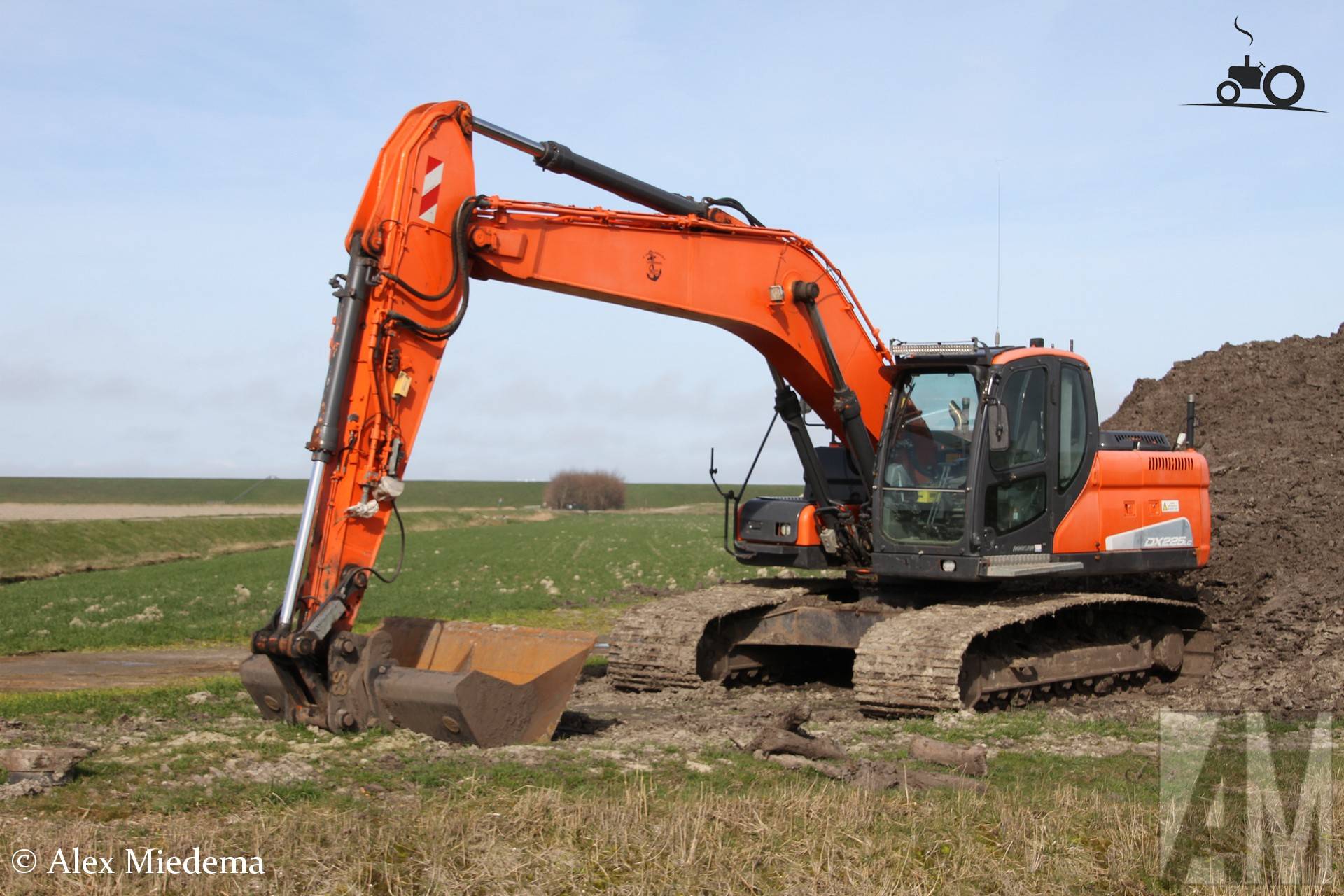 Doosan DX 225 LC graafmachine tussen zeedijk en Oosterbierum