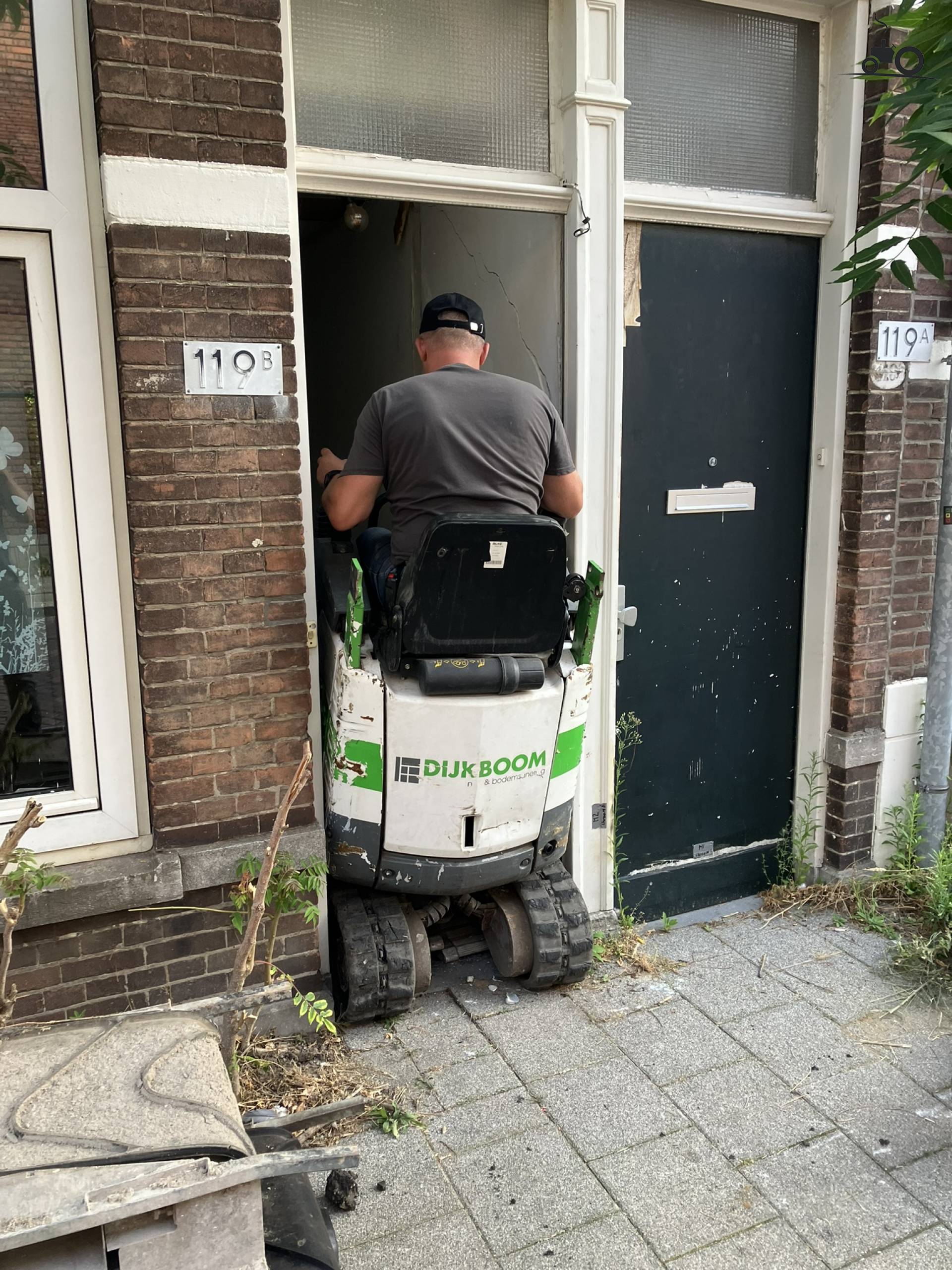 Bobcat E10 rijdt een Amsterdams grachtenpand in