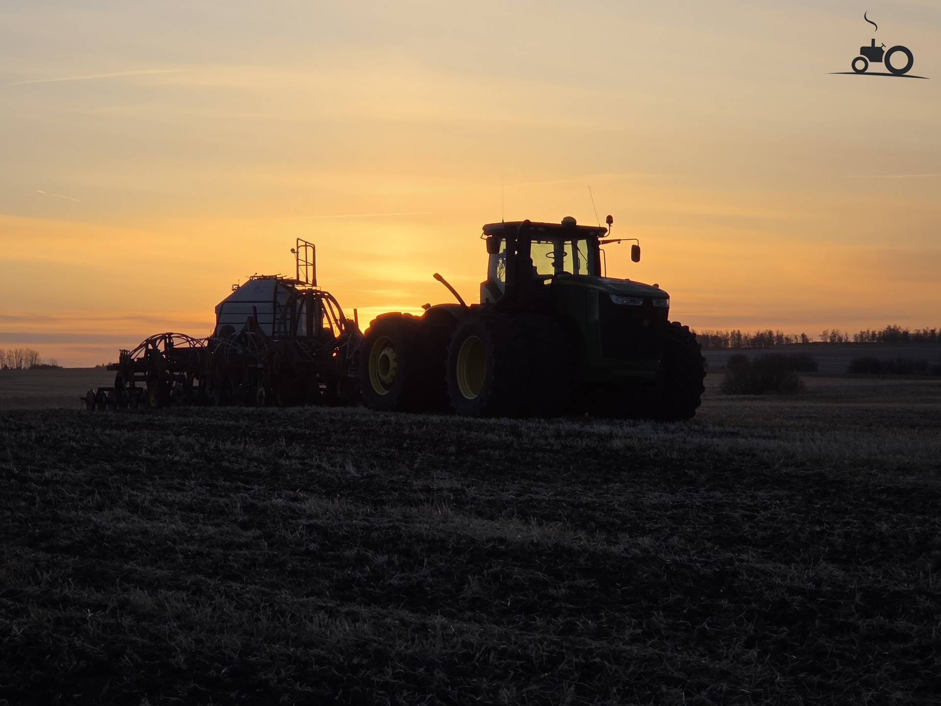 John Deere 9360R met airseeder bij zonsondergang