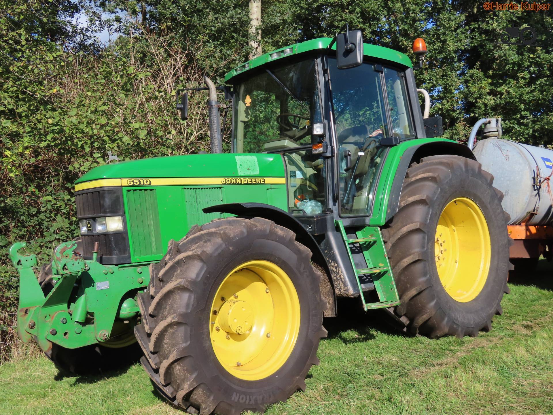 Vintage scène van de maïsoogst met een John Deere 6510
