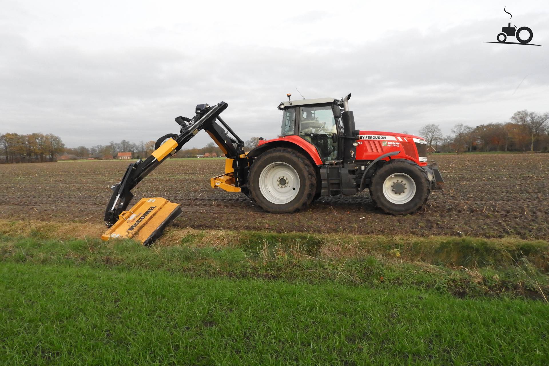 Tagliare l'erba lungo i canali con un Massey Ferguson 7620 di Tolkamp.