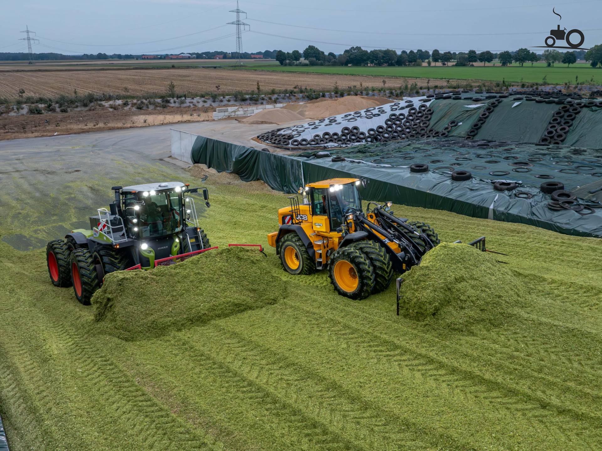 JCB 457S and Claas Xerion 4200 compacting silage on dual wheels