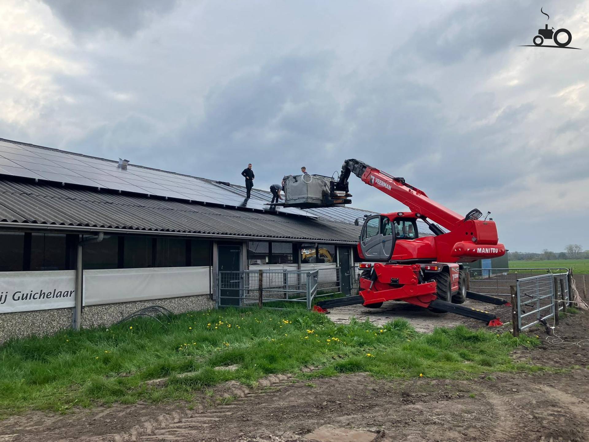 A Manitou telehandler is installing solar panels on a young cattle barn.